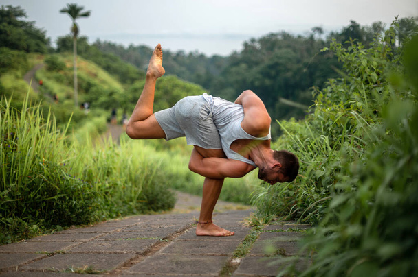 Чоловік практикує йогу і медитує на вулиці - Фото, зображення