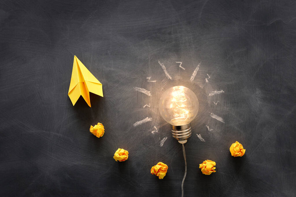 Education concept image. Creative idea and innovation. Light bulb as metaphor over blackboard - Fotó, kép