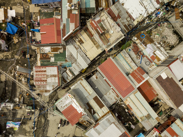 Vue de dessus d'un squatter sordide et appauvri avec des passages étroits et des toits en métal ondulé à Las Pinas
. - Photo, image