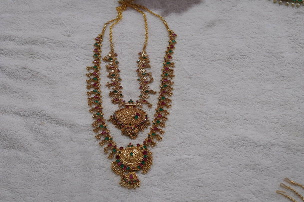 Una bella collana d'oro artificiale con pietre gemma multicolore su sfondo bianco
. - Foto, immagini
