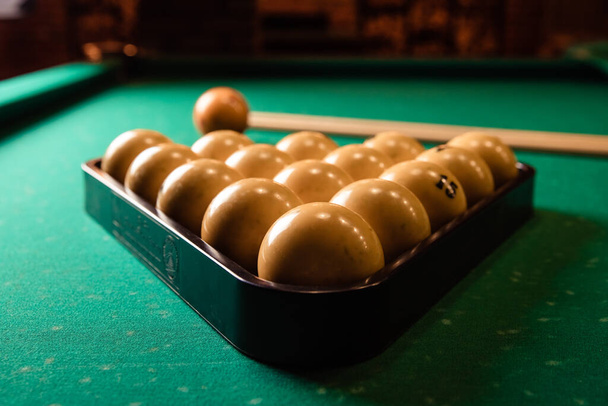 billiard cues and pyramid of yellow pool balls on green billiard table.Billiard table with balls. Close-up - Foto, afbeelding