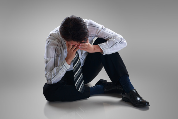 Stressaantunut pettynyt liikemies istuu yksin lattialla
 - Valokuva, kuva