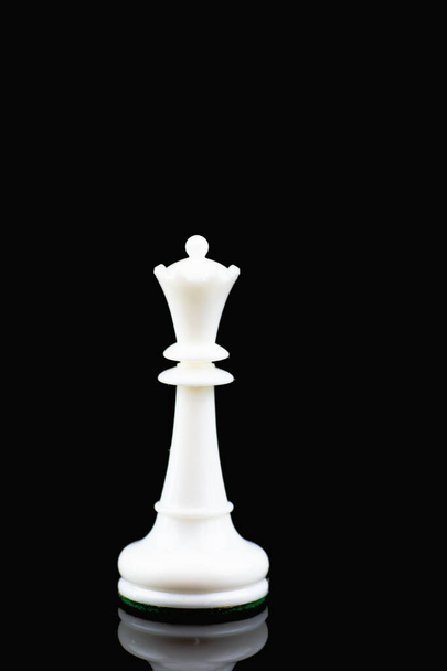 Piezas de ajedrez de plástico blanco y negro en un tablero de ajedrez marrón y blanco con un reloj de ajedrez
 - Foto, Imagen