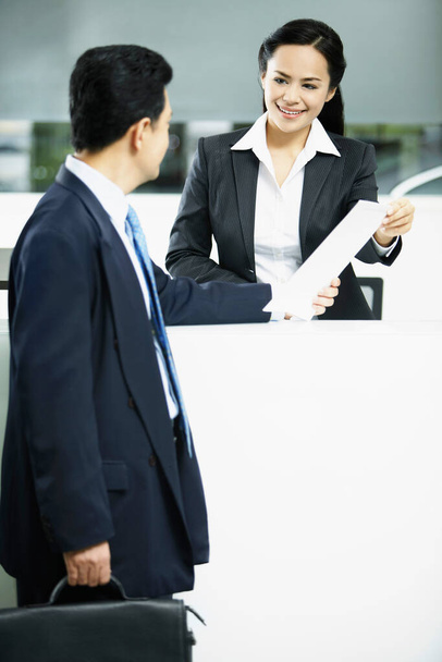 Sales representative interacting with a customer at the counter - Foto, Imagen