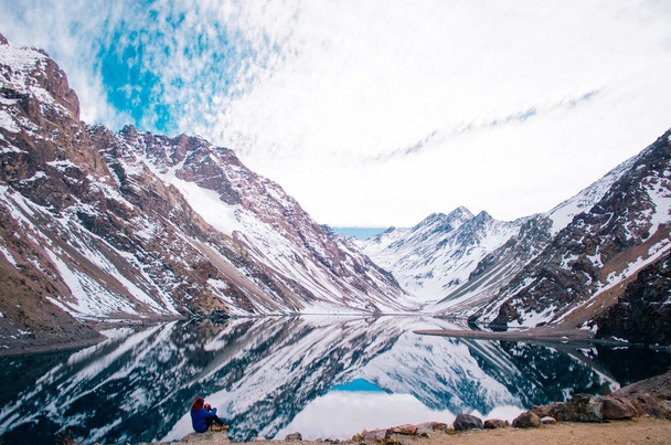 Zrzka mladá dospělá žena pózující před Andes Mountains s modrou bundou a odvracející se od kamery. - Fotografie, Obrázek
