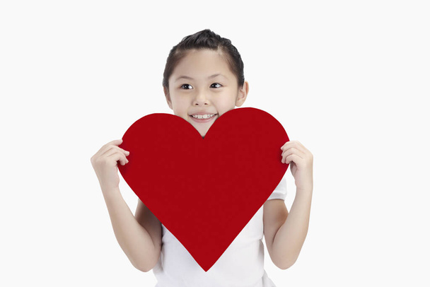 Girl holding a big cut out heart - 写真・画像