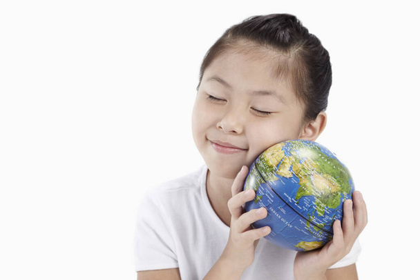 Girl holding globe to her cheek - Foto, imagen