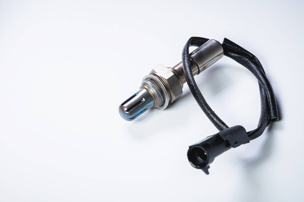 The oxygen sensor is a new lambda sensor. Spare parts on the car on a gray gradient background - Foto, immagini