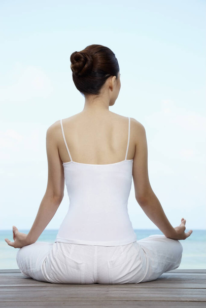 Woman meditating, back view - Фото, изображение