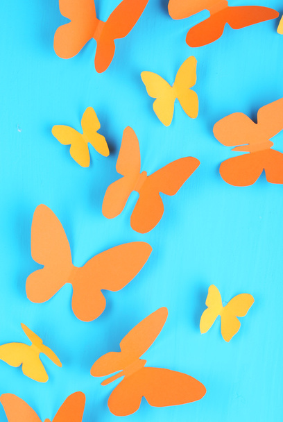 Paper butterflies on blue wooden board background - 写真・画像