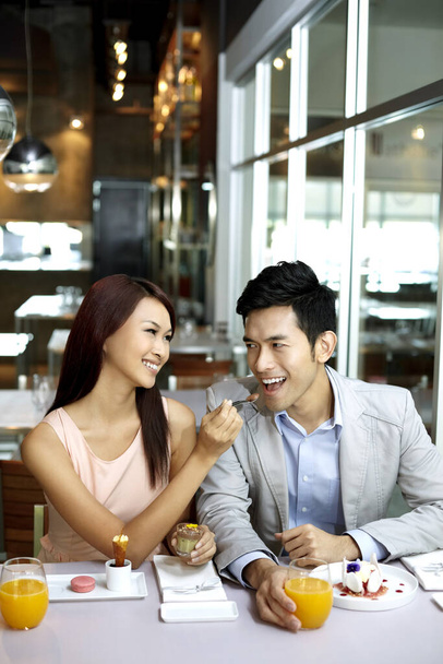Woman feeding man in restaurant - Foto, afbeelding