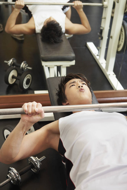 Man lifting weights in gym - Фото, зображення
