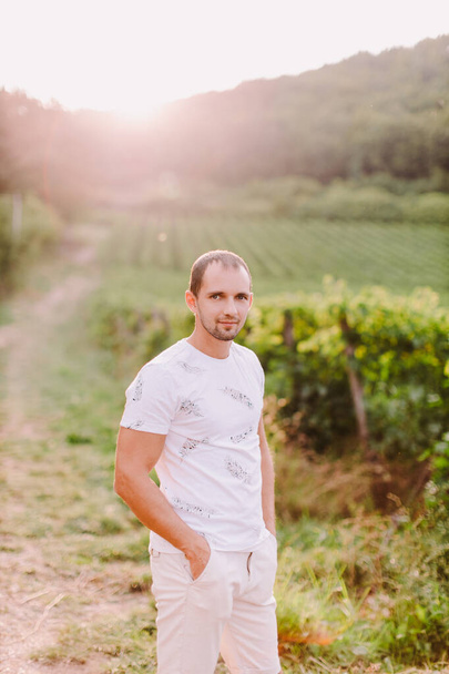 портрет мужчины в сельской местности на закате. Красивый мужчина в сельских виноградниках смотрит в камеру. Владелец фермы. Италия - Фото, изображение