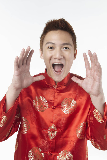 Excited man in traditional clothing shouting with mouth and hands cupped - Photo, image