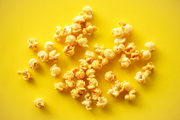 Popcorn on yellow paper background  - Фото, изображение
