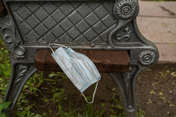 protective mask hanging on a bench - Photo, Image