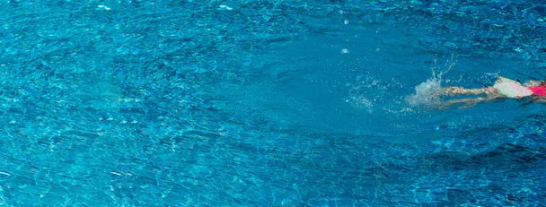 girl legs swimming in the fresh blue pool summer water for vacation web banner background - Photo, Image