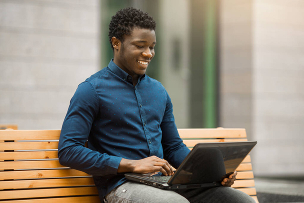 jóképű fiatal afrikai férfi ül laptop - Fotó, kép