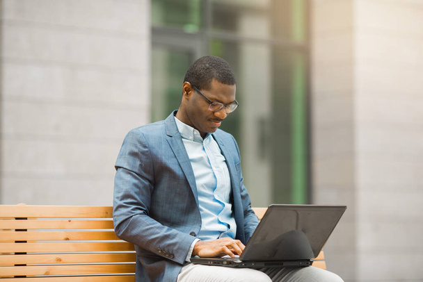 handsome young african man sitting with laptop - Foto, Imagen