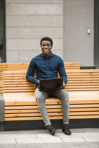 handsome young african man sitting with laptop - Fotografie, Obrázek