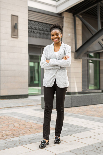 όμορφη νεαρή Αφρικανή με σακάκι κοντά στο κτίριο. - Φωτογραφία, εικόνα