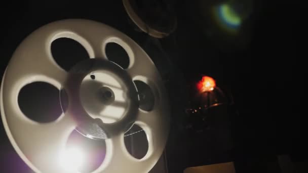 Bobine avec un film rotatif et des rayons lumineux. Vieux projecteur de film - Séquence, vidéo