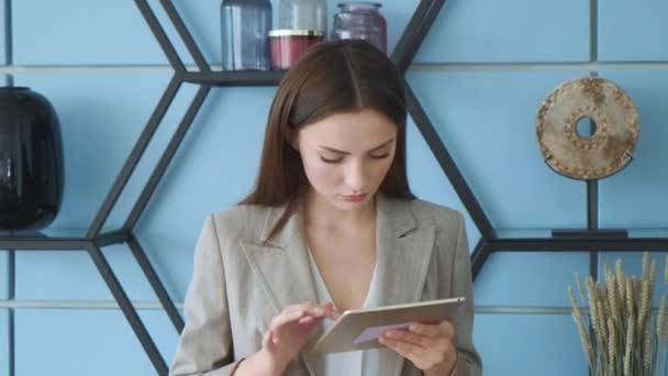 Focused woman holding using digital tablet online apps at home office, young ethnic girl surfing web working studying in internet spending time with modern device technology indoors
 - Кадры, видео