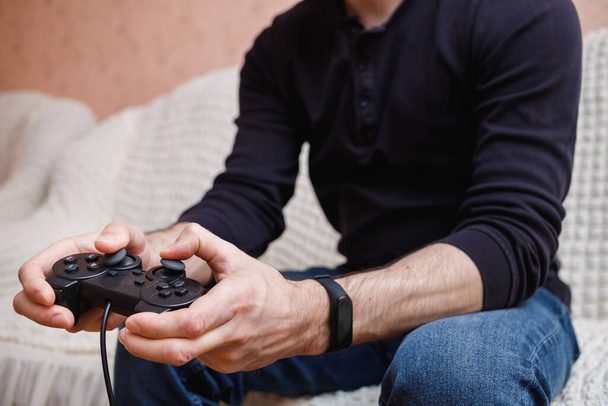  Мужчина играет в видеоигры с джойстиком в руках
 - Фото, изображение