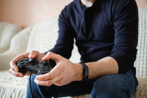  Um homem joga videogames com um joystick em suas mãos
 - Foto, Imagem