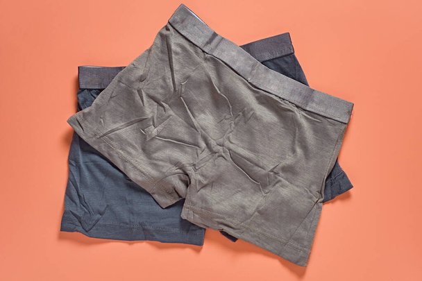 Two dark new male underpants, boxers on orange background. Top view. Close-up - Valokuva, kuva