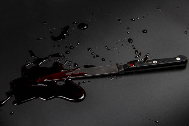 Cuchillo con sangre en el fondo blanco. Fondo sangriento con cuchillo - foto conceptual
. - Foto, imagen