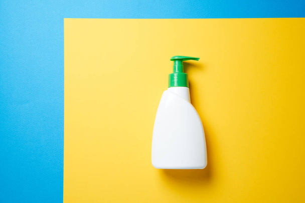 Soap bottle over blue background. Top view flat lay. - Фото, зображення