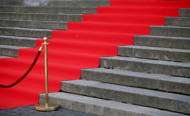 Elegancki długi czerwony dywan na szerokich schodach zabytkowego budynku - Zdjęcie, obraz