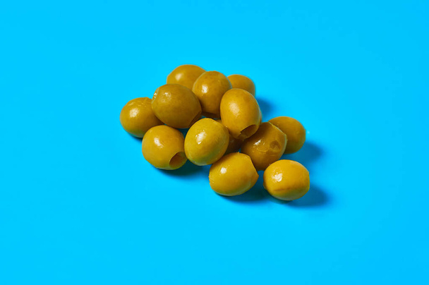Heap of many pickled olives on blue table on kitchen. Close-up - Foto, Imagem