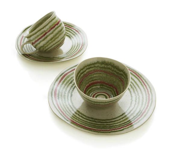 Groene thee kopjes met kleine borden, witte achtergrond, geïsoleerd. Set van Aziatische thee kopjes en borden op witte achtergrond bovenaanzicht. - Foto, afbeelding