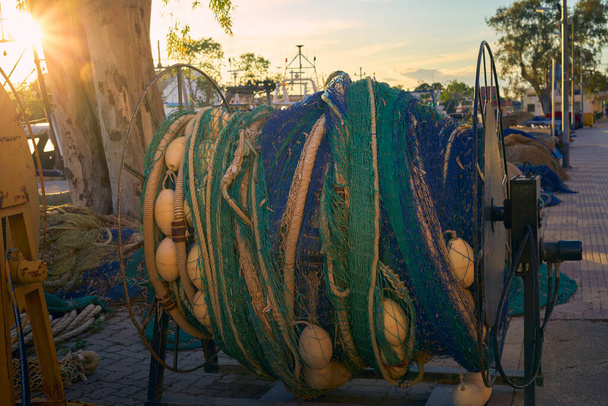 Rybářské sítě se válely na navijákových bubnech na vlečné lodi kotvící v přístavu. Zlatá hodina - Fotografie, Obrázek