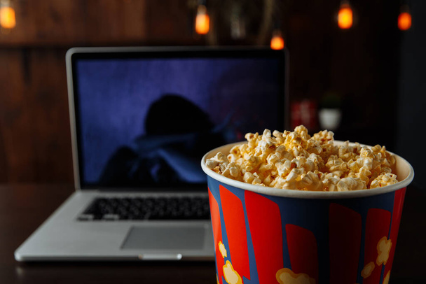 Veel plezier met het kijken naar een film op een laptop met popcorn - Foto, afbeelding