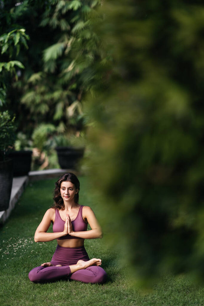 Woman practicing yoga performing yoga-asanas outdoors. - Φωτογραφία, εικόνα