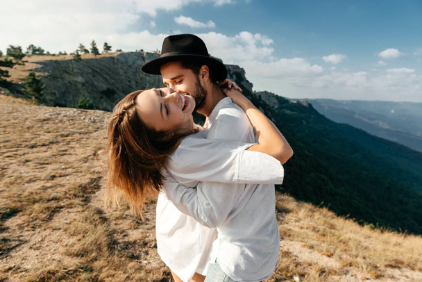 Attractive young loving couple of man and woman in the green mountain landscape - Foto, imagen