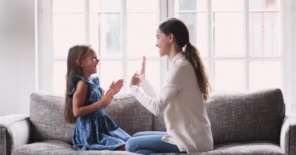 Smiling cute girl playing patty cake game with caring mother. - Filmmaterial, Video