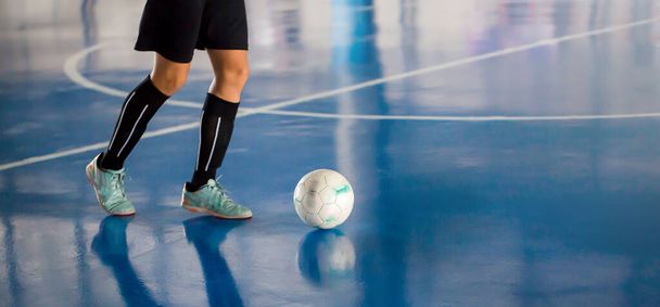 Futsalspieler kontrollieren den Ball, um ins Tor zu schießen. Fußballhallensporthalle. Futsalspieler, Ball, Futsalboden. - Foto, Bild