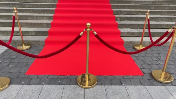 Elegantní dlouhý červený koberec na širokých schodech historické budovy - Záběry, video