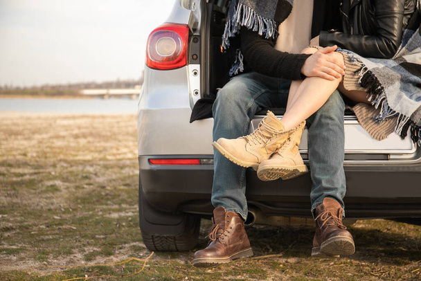 Loving couple sitting in the trunk of a car - Zdjęcie, obraz