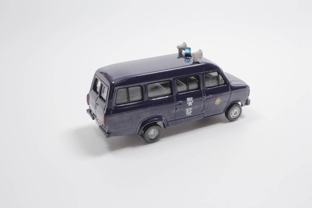 Модель поліцейського автомобіля з фігурою на білій дошці.. - Фото, зображення