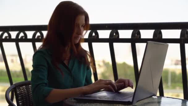  biuro dziewczyna pracuje na balkonie na laptopie - Materiał filmowy, wideo
