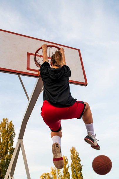 Females playing basketball on street court. Woman streetball player making slam dunk in a basketball game. - Foto, Bild
