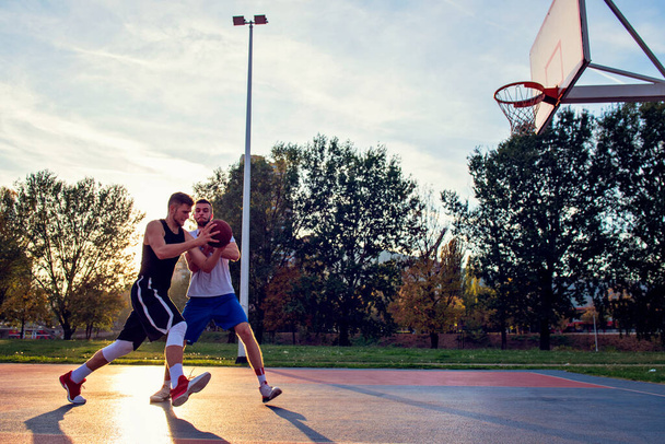Two street basketball players playing hard on the court - Zdjęcie, obraz