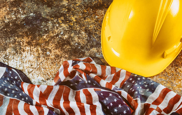 Happy Labor Day USA patriotic, yellow hard hat construction helmet USA flag over wooden deck table background. - Photo, Image