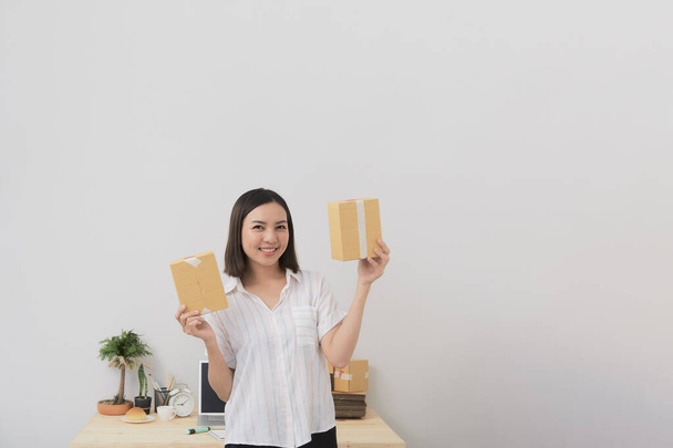 Young Thai woman business Online shopping at work from home Packing Prepare to Deliver the package Postal and delivery package through a service, courier service concept - Fotoğraf, Görsel