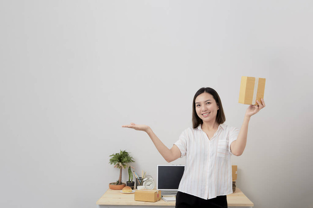 Young Thai woman business Online shopping at work from home Packing Prepare to Deliver the package Postal and delivery package through a service, courier service concept - Photo, image